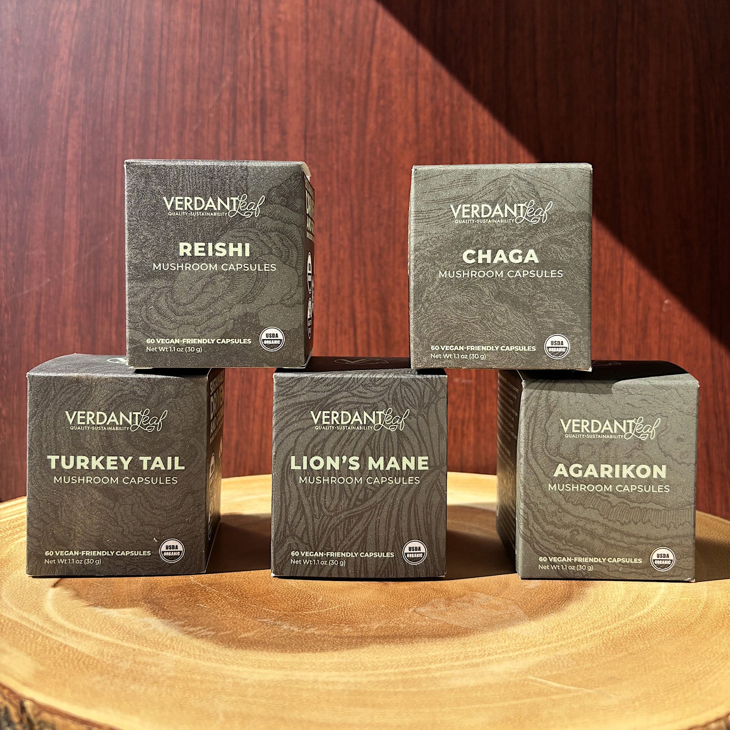 Five boxes of Verdant mushroom capsules on a wooden surface with a wooden background